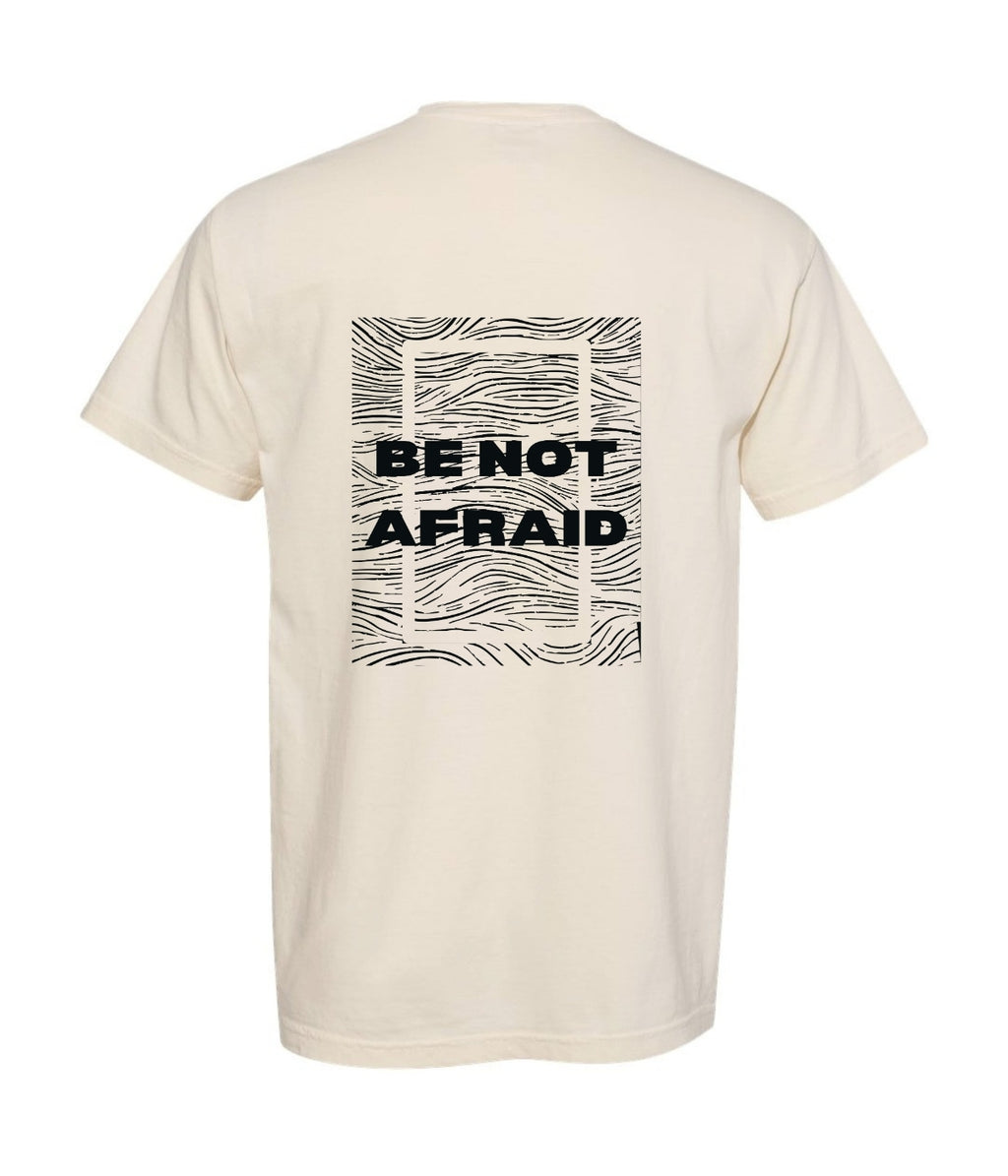 Beige t-shirt with 'BE NOT AFRAID' text on the back against a white background